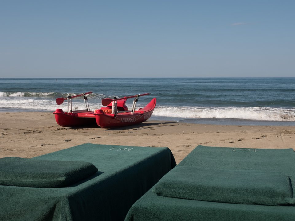 Lettini con i teli verdi e i pattini di salvataggio tirati a riva